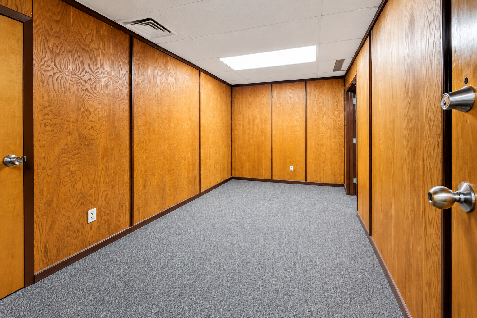 Executive suite with a desk, seating, and warm professional finishes