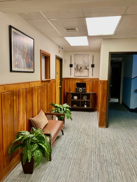 Bright hallway and common area with seating and plants