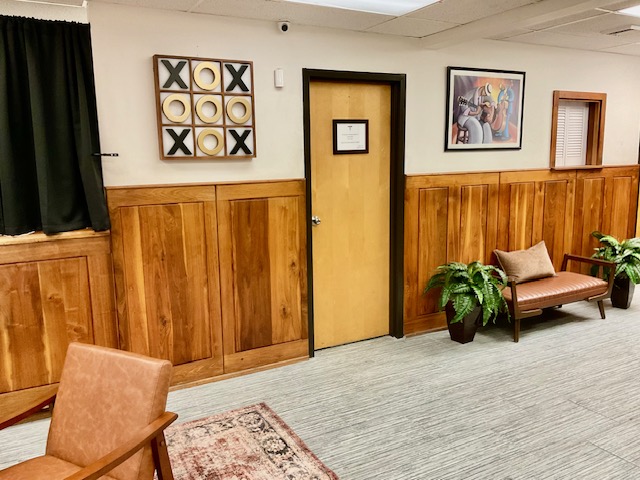 Sitting room with leather bench, accent chair, and playful tic-tac-toe wall art